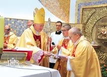 Biskup tarnowski Andrzej Jeż przekazuje ks. Edwardowi Litakowi świadectwo dedykacji kościoła.