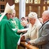 Bp Henryk Ciereszko i o. Robert Więcek SJ składają życzenia jubilatom.