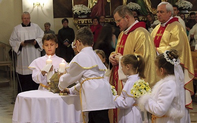 Ks. Henryk Oleś z pierwszokomunijnymi dziećmi wniósł relikwie bł. ks. Jerzego Popiełuszki, złożone później w ołtarzu.