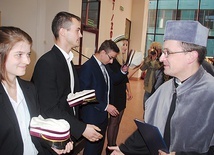 Ks. dr Bartłomiej Krzos gratuluje nowym studentom.