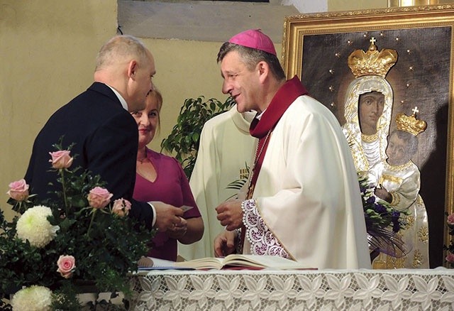 ▲	Parafianie i bp Roman Pindel, a za nimi – obraz Matki Bożej w nowej sukience.