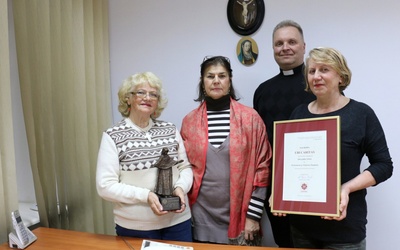 Ks. Robert Kowalski z wolontariuszkami (od prawej): Jadwigą Gozdór, Barbarą Bandyką i Zofią Piątek w siedzibie telefonu zaufania