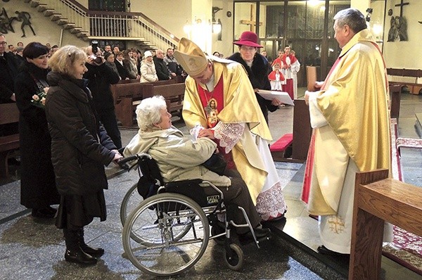 Małgorzata Fita odbiera medal Akcji Katolickiej z rąk bp. Romana Pindla.