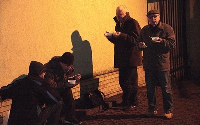 Bezdomnym smakuje krupnik, ale nieliczni gawędzą podczas posiłku.