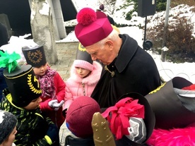 Biskup pod pomnikiem rozdał dzieciom obrazki.