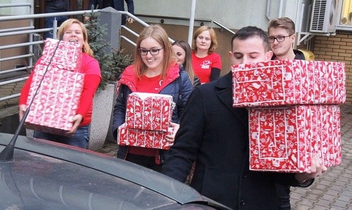 Wspólne ładowanie prezentów do samochodów przed andrychowskim magazynem Szlachetnej Paczki
