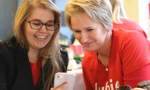 Agnieszka Rojczyk i Joanna Seel, lider rejonu, oglądają zdjęcia z przekazania paczki 