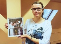 ▲	Aneta Korzuśnik z pamiątkowym zdjęciem. Przedstawia ono Jana Pawła II błogosławiącego obraz Jezusa Miłosiernego, który znajduje się w kaplicy placówki. 