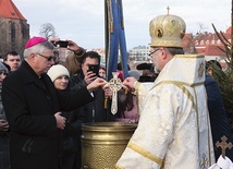 Jednym z elementów obrzędu jest zanurzenie w wodzie krzyża.