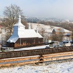 Zza drzew jaśnieją białe wieżyczki. To śliczna cerkiew Świętego Archanioła Michała w Przysłupiu.