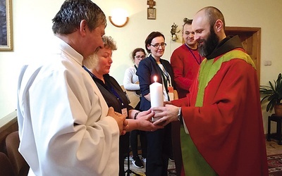 Ojciec Walenty i para organizująca rekolekcje ze świecą oznaczającą obecność Chrystusa.