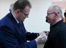 Szef Urzędu do spraw Kombatantów i Osób Represjonowanych wręcza medal ks. prał. Eugeniuszowi Jankiewiczowi.