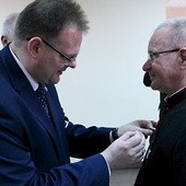 Szef Urzędu do spraw Kombatantów i Osób Represjonowanych wręcza medal ks. prał. Eugeniuszowi Jankiewiczowi.
