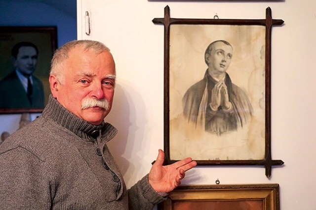 Waldemar Krzyżewski przy jednym z obrazów świętego.