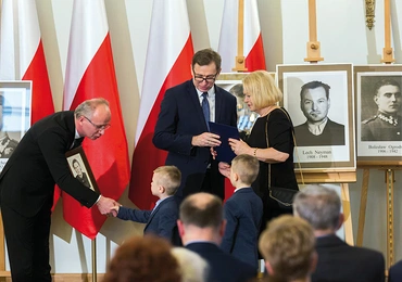 Magdalena Zarzycka odbiera notę identyfikacyjną swojej mamy Stefanii. Podczas uroczystości towarzyszą jej wnukowie. – Chcę, żeby chłopcy zapamiętali tę chwilę na całe życie – mówi pani Magdalena.