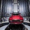 Ten sportowy samochód Tesla Roadster w kolorze wiśniowym leci w kierunku Marsa  na pokładzie rakiety Falcon Heavy.