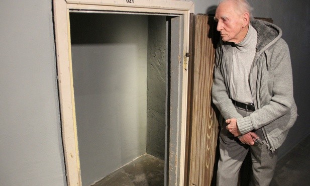 Wacław Gluth-Nowowiejski przy dawnym karcerze - małym, niskim pomieszczeniu pod schodami.