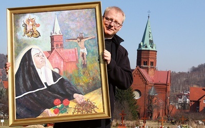 Ks. Maciej Sroczyński pokazuje obraz św. Rity z kościoła św. Jerzego i MB Różańcowej w Wałbrzychu.