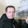 Ks. Andrzej Kapica pokazuje odkrywki tynku w ścianie