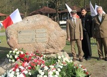 Obok obelisku stoi Piotr Kacprzak (z lewej), autor projektu obelisku Jacek Szpak i  płk Ryszard Gregorczyk (z prawej)