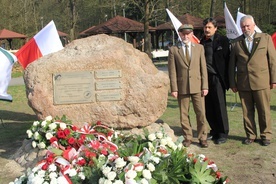 Obok obelisku stoi Piotr Kacprzak (z lewej), autor projektu obelisku Jacek Szpak i  płk Ryszard Gregorczyk (z prawej)