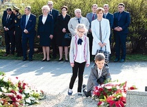 Uczniowie zabrzańskich szkół składają kwiaty przy tablicach upamiętniających ofiary zbrodni katyńskiej i katastrofy smoleńskiej. W tle przedstawiciele władz miasta.