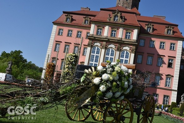 Przed budynkiem stoją okwiecone wozy, jednak najwięcej kompozycji jest w środku