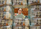Urzędniczka w banku sprawdza, czy 100-dolarowe banknoty są fałszywe. 
4.05.2018 Seul, Korea Płd.