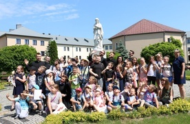 Klerycy i ich goście przy figurze Matki Bożej Niepokalanej w seminaryjnym wirydarzu