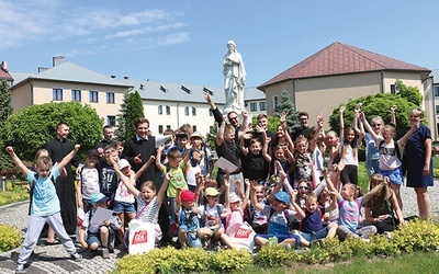 Klerycy i ich goście przy figurze Matki Bożej Niepokalanej w seminaryjnym wirydarzu.