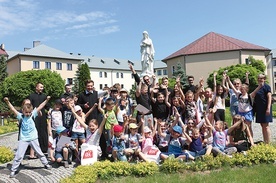 Klerycy i ich goście przy figurze Matki Bożej Niepokalanej w seminaryjnym wirydarzu.