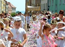 Dzieci usłały niesionemu Panu Jezusowi dywan kwiatów.