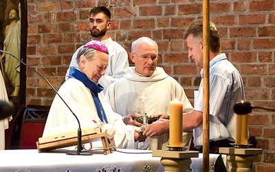 Bp Gerard Kusz i ks. Waldemar Niemczyk, diecezjalny duszpasterz rodzin, odbierają dary ofiarne.