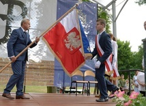 Poświęcony sztandar przekazuje uczniom Jan Słuszniak, dyrektor placówki w Baryczy