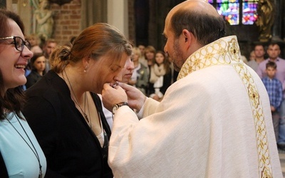 Magdalena Kubińska całuje pobłogosławiony wcześniej Krzyż Misyjny.