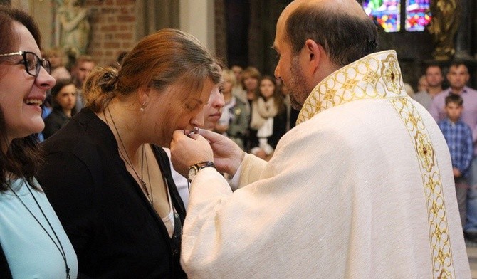 Magdalena Kubińska całuje pobłogosławiony wcześniej Krzyż Misyjny.