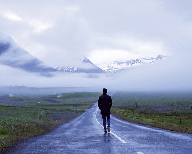 Człowiek na drodze. 
W tle wulkaniczne góry spowite mgłą.
25.06.2018 
Islandia, Sauðárkrókur