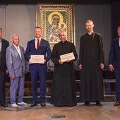 ▲	W środku z dyplomami stoją Adam Sondka i ks. Andrzej Sałkowski.