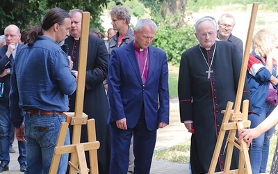 Biskupi Marcin Hintz i Jacek Jezierski oglądają wystawę poświęconą pracom wykonanym przy lapidarium.