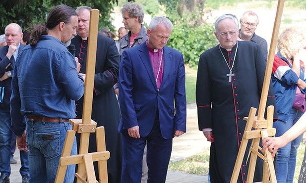 Biskupi Marcin Hintz i Jacek Jezierski oglądają wystawę poświęconą pracom wykonanym przy lapidarium.