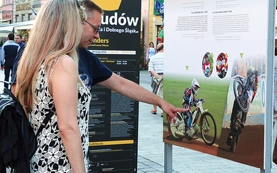 Przechodnie i turyści chętnie zatrzymują się przy wystawie. Ich wzrok przyciąga efektowna jazda na żużlowych motocyklach.