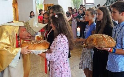 Uczestnicy rekolekcji przynieśłi do ołtarza świece oazowe i bochny chleba