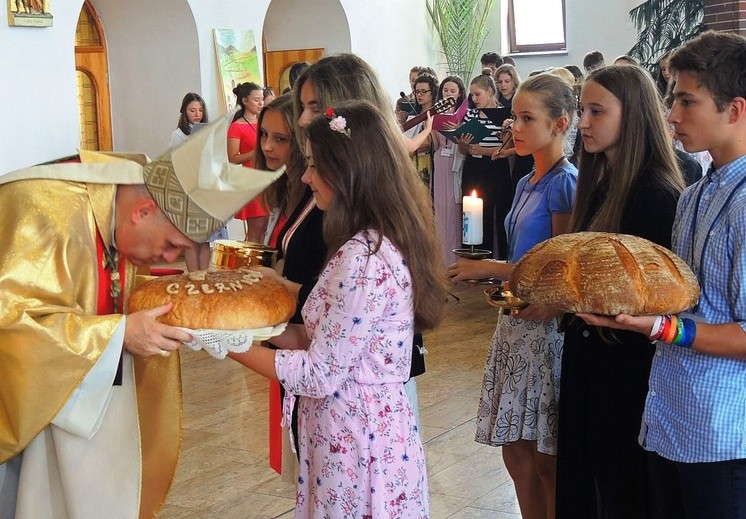 Uczestnicy rekolekcji przynieśłi do ołtarza świece oazowe i bochny chleba