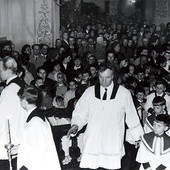 Stanisław Psiuk prowadzący procesję ministrantów przez wypełnioną po brzegi bazylikę.