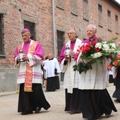 Od prawej: abp Marek Jędraszewski, abp Ludwig Schick i bp Roman Pindel przed Ścianą Śmierci na dziedzińcu bloku 11