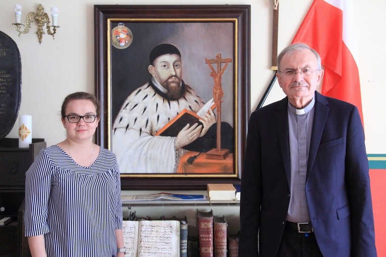 Amelia Waszkiewicz i ks. Grzegorz Rafiński prezentują portret o. Rowedera, który w oryginale znaleźć można w oliwskiej świątyni