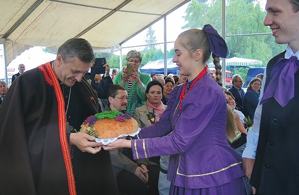 Bp Roman Pindel przyjmuje chleb z tegorocznych plonów z rąk młodych z zespołu Ziemia Beskidzka.