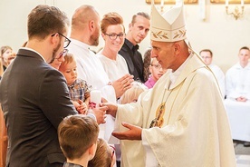 ▲	Biskup Andrzej wręcza świece rodzinom, które wstępują do Domowego Kościoła.