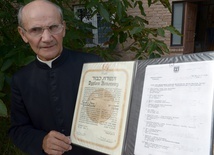 Ks. Stanisław Kosowicz pokazuje dyplom Instytutu Yad Vashem przyznany jego rodzicom