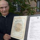 Ks. Stanisław Kosowicz pokazuje dyplom Instytutu Yad Vashem przyznany jego rodzicom